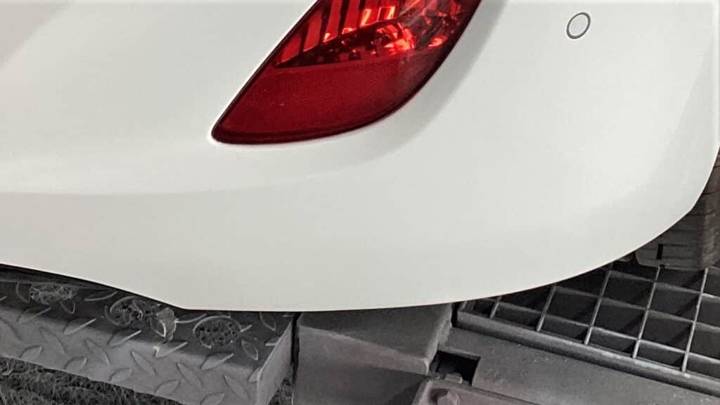 Hvid Nissan Micra med repareret revne i kofanger