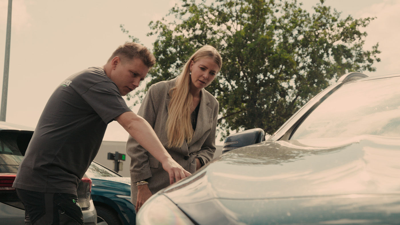 Kunde gennemgår bilskade sammen med tekniker fra Carbucks før reparation