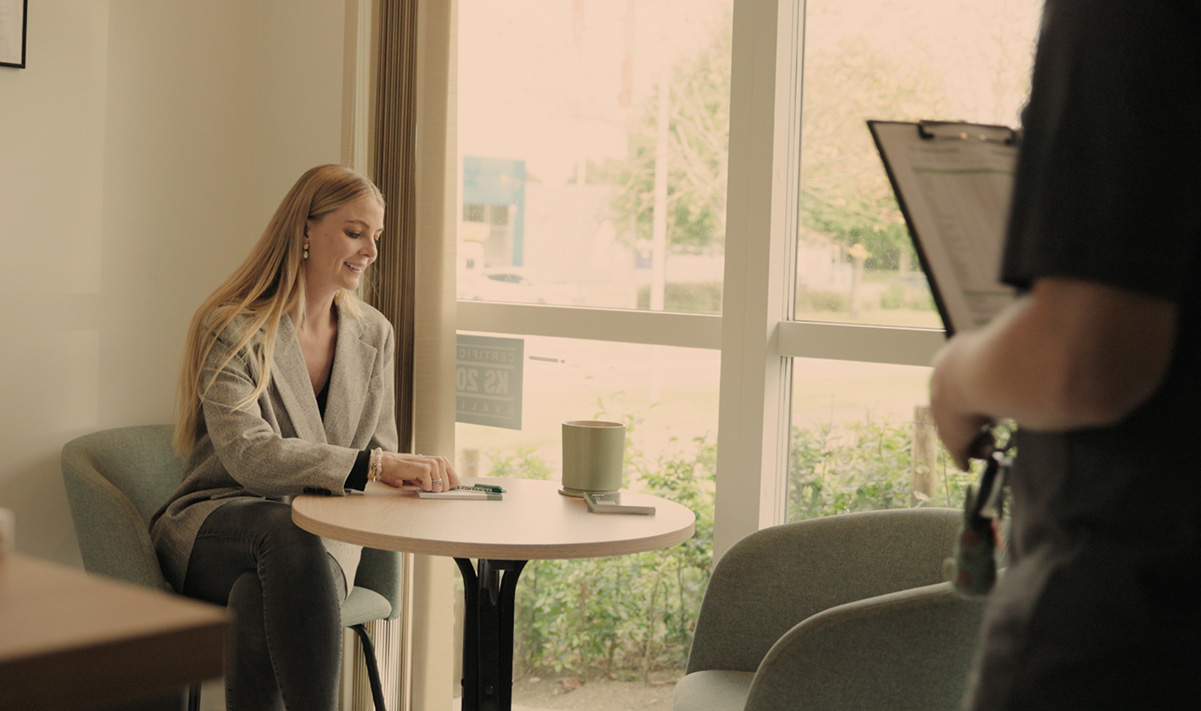 Kunde venter i roligt loungeområde med kaffe under bilreparation