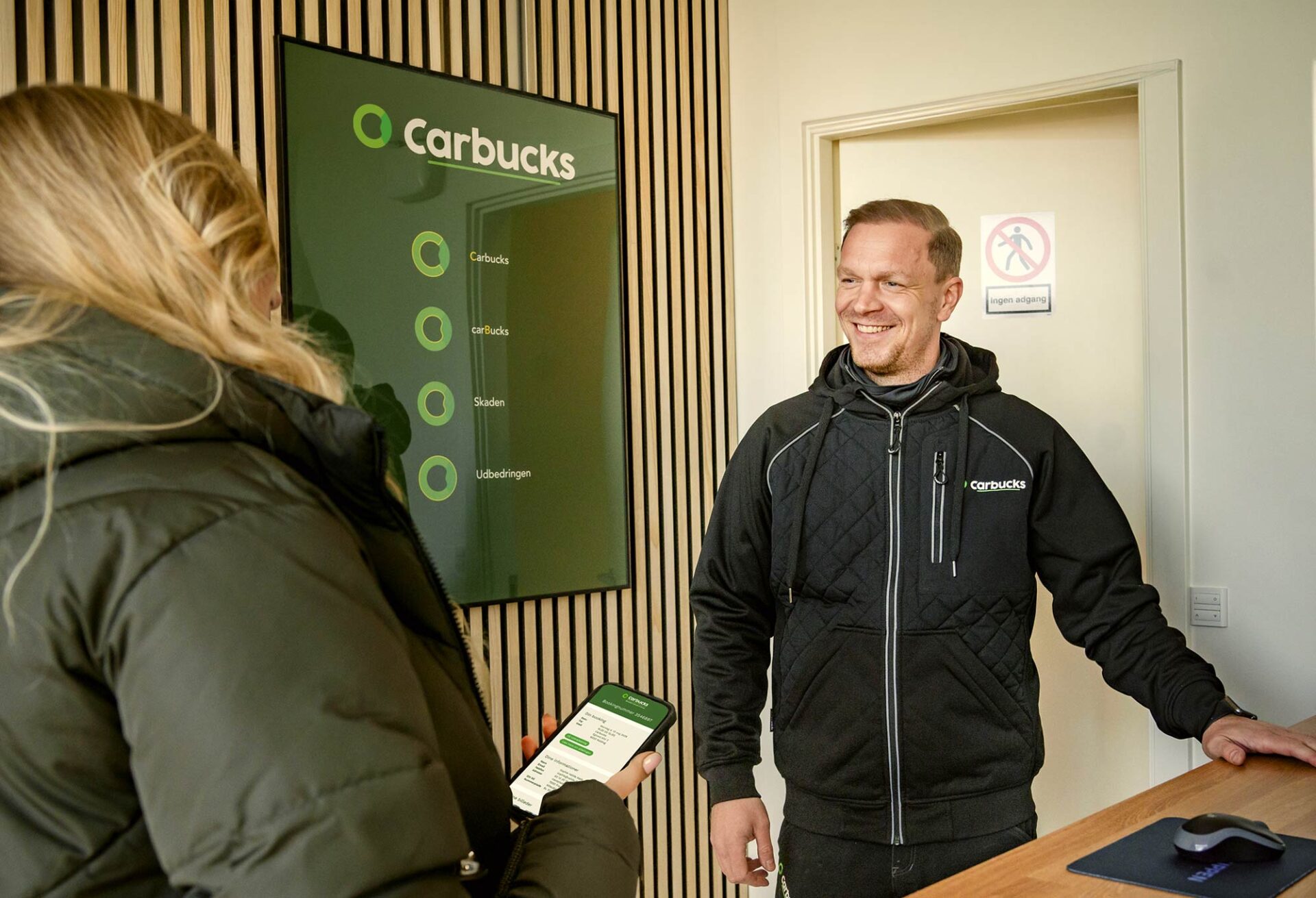 Kunde taler med medarbejder hos Carbucks ved ankomst til værksted