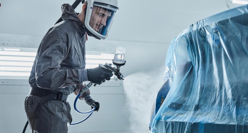 Lakering af bil med beskyttelsesudstyr og præcis sprøjteteknik