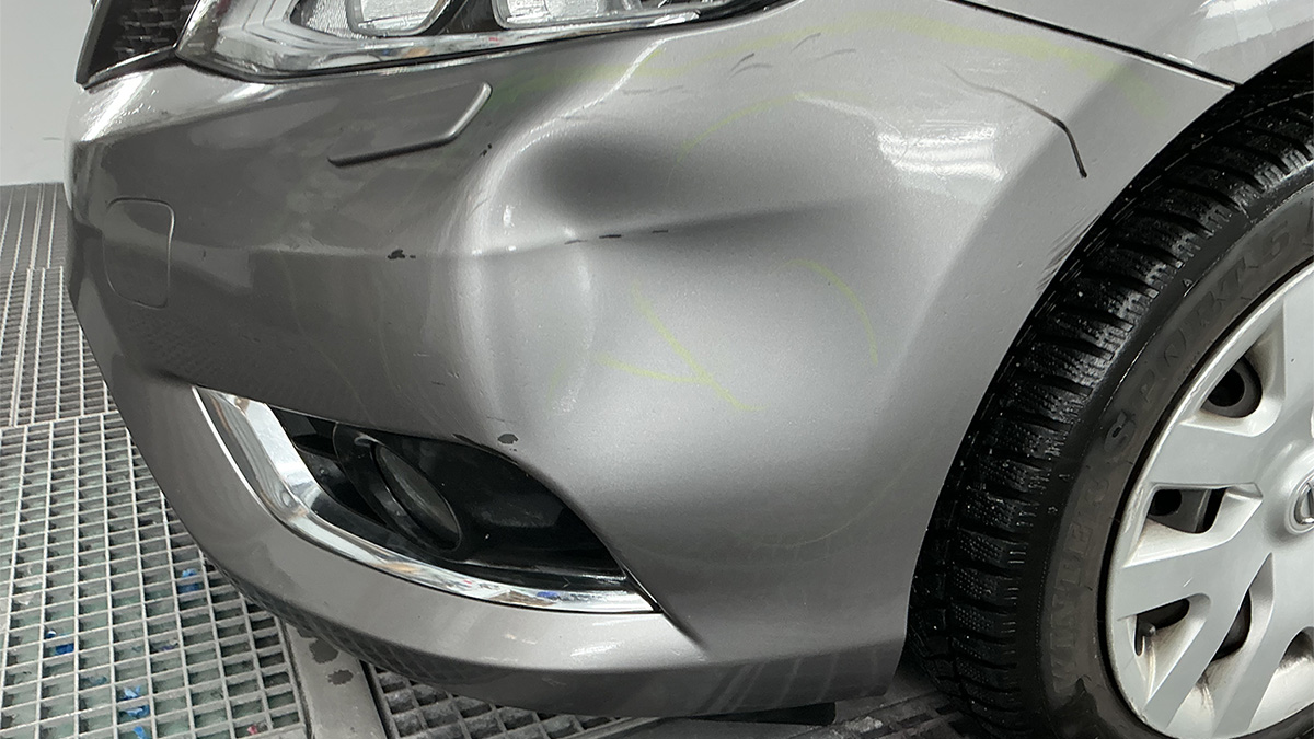 Bule og ridser på bilens kofanger før reparation hos Carbucks