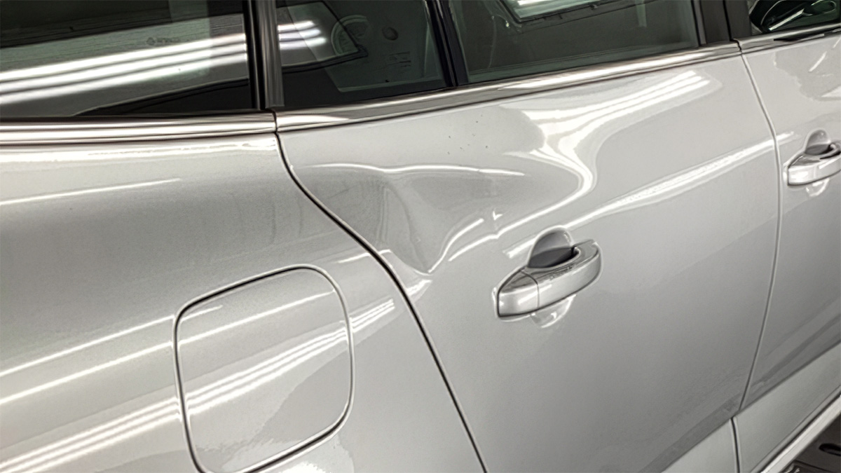 Bule og ridser på bilens dør før reparation hos Carbucks